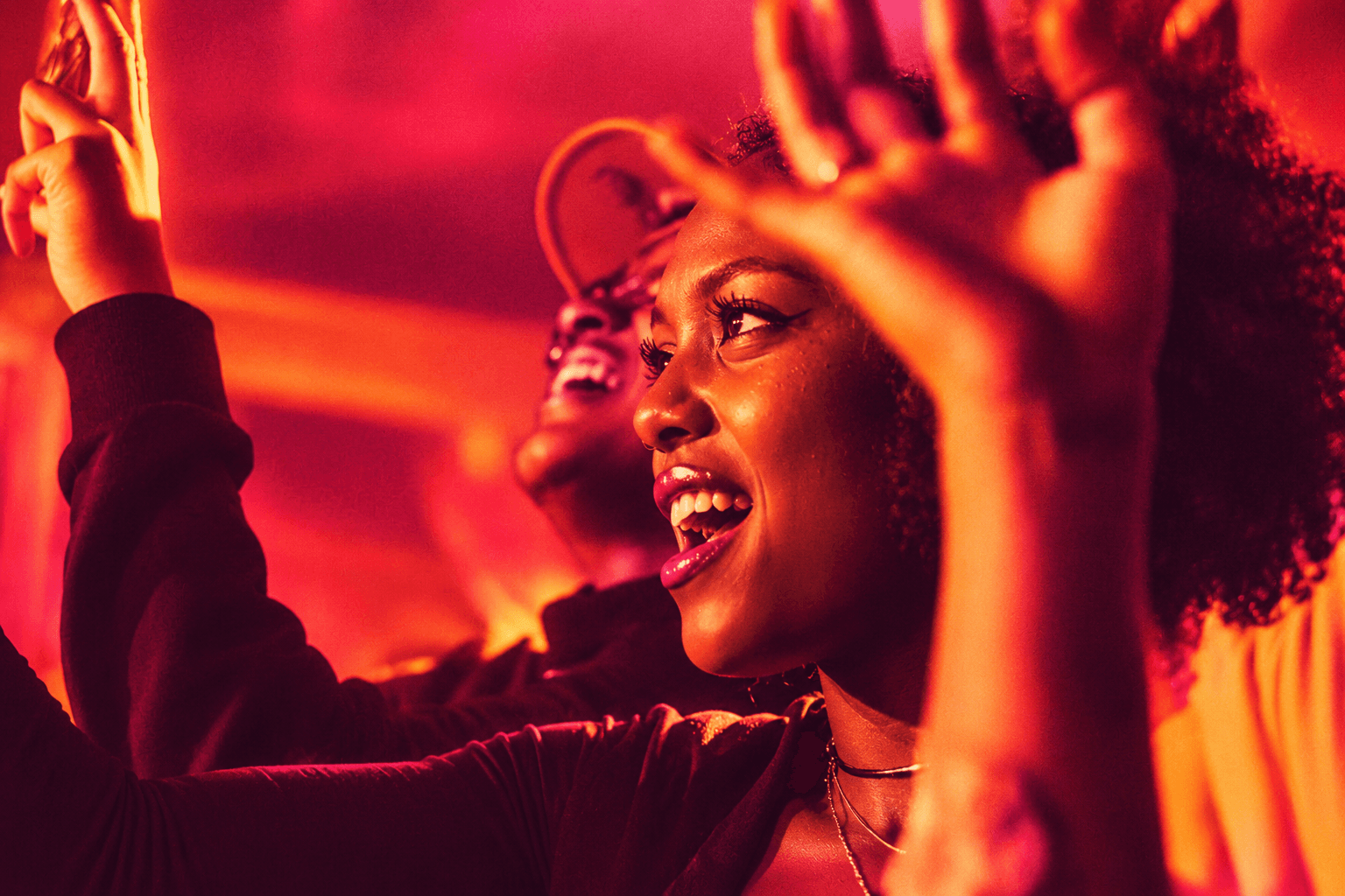 Fans with their hands raised in the crowd at a live show